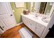 Bathroom featuring a white vanity, hardwood floors, and olive green walls at 197 Westbrook Rd, Carrollton, GA 30116