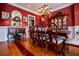 Beautiful dining room featuring red walls, hardwood floors, a chandelier, and elegant furnishings for memorable gatherings at 197 Westbrook Rd, Carrollton, GA 30116