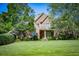 Traditional two-story brick home with a lush green lawn and mature trees in a serene setting at 197 Westbrook Rd, Carrollton, GA 30116
