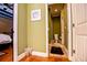 Hallway with view to a bathroom, featuring green walls and hardwood floors at 197 Westbrook Rd, Carrollton, GA 30116