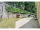 Backyard view with lush green landscaping and retaining wall at 5003 Village Terrace Dr, Dunwoody, GA 30338