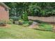 Well-manicured backyard featuring a lush lawn, terraced garden with stone steps, and a privacy fence at 5003 Village Terrace Dr, Dunwoody, GA 30338