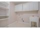 Laundry room featuring white cabinetry, shelving, and a utility sink at 5003 Village Terrace Dr, Dunwoody, GA 30338