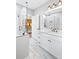 This bathroom features double sinks, marble floors and a frameless shower at 8175 Main St, Woodstock, GA 30188