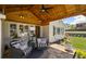 Covered front porch with cozy seating, manicured landscaping, and classic brick exterior at 8175 Main St, Woodstock, GA 30188
