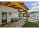 Inviting covered patio with stone flooring, a seating area, and a view of the pool and outdoor kitchen at 8175 Main St, Woodstock, GA 30188