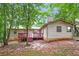Backyard showcasing a wooden deck, mature trees and a mix of grassy and wooded areas at 1024 Stone Mill Run, Lawrenceville, GA 30046
