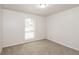 Bright bedroom with a neutral color palette, plush carpeting, and a window offering natural light at 1024 Stone Mill Run, Lawrenceville, GA 30046
