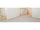 Bright, open-concept living area with neutral walls and carpeting, with a view into the kitchen at 1024 Stone Mill Run, Lawrenceville, GA 30046