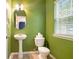 Powder room with a pedestal sink, toilet, mirror, and window at 126 Wellbrook Ne Ct, Conyers, GA 30012