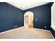 Bedroom featuring modern chandelier, neutral carpet, blue accent wall, and a large window at 126 Wellbrook Ne Ct, Conyers, GA 30012