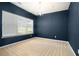 Bedroom featuring modern chandelier, neutral carpet, blue accent wall, and a large window at 126 Wellbrook Ne Ct, Conyers, GA 30012