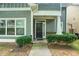Inviting front entrance with a dark wood door, white pillars, and manicured bushes at 126 Wellbrook Ne Ct, Conyers, GA 30012