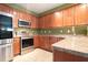 Traditional kitchen with stainless steel appliances and warm wood cabinetry offering ample storage space at 126 Wellbrook Ne Ct, Conyers, GA 30012