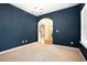 Room featuring plush carpeting, neutral walls, large windows, and an arched doorway leading to another room at 126 Wellbrook Ne Ct, Conyers, GA 30012