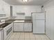 Well-lit kitchen with tile flooring, ample counter space and white appliances and cabinets at 1480 Pine Log Ne Rd # D, Conyers, GA 30012