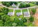 An aerial view showcases three homes, each with expansive, verdant lawns at 3012 Flat Shoals Rd, Conyers, GA 30094
