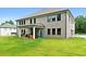 A large backyard with a well-manicured lawn, covered patio, grill, and view of the home's rear brick facade at 3012 Flat Shoals Rd, Conyers, GA 30094