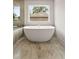 Freestanding white soaking tub situated in a bathroom with stone-look tiled floors at 3012 Flat Shoals Rd, Conyers, GA 30094