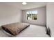 A minimalist bedroom features a bare mattress, gray walls, and a window offering natural light and views at 3012 Flat Shoals Rd, Conyers, GA 30094