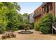 Picturesque courtyard featuring a central fountain, benches, and lush greenery in a tranquil setting at 9071 Selborne Ln, Chattahoochee Hills, GA 30268