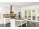 Bright kitchen with an island, granite countertops, and stainless steel appliances at 9071 Selborne Ln, Chattahoochee Hills, GA 30268