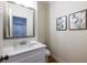 Half bathroom featuring granite countertop, chrome faucet and fixtures, wood floors, and modern artwork at 1542 Idlewood Rd, Tucker, GA 30084