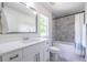 Bright bathroom with white vanity, framed mirror, and a bathtub with marble-style tile surround at 1542 Idlewood Rd, Tucker, GA 30084
