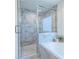 Modern bathroom with a glass shower featuring elegant marble tiling, next to a soaking tub at 1542 Idlewood Rd, Tucker, GA 30084