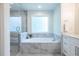Main bathroom features a large tub with marble tile surround, and a glass enclosed shower at 1542 Idlewood Rd, Tucker, GA 30084
