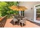 Outdoor deck with a table, chairs, an umbrella, and a view of the backyard at 1542 Idlewood Rd, Tucker, GA 30084