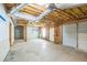 Unfinished basement with concrete flooring, exposed ceiling and framing, leading to a garage with a door at 167 Gothards Creek Dr, Powder Springs, GA 30127