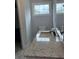 Bright bathroom featuring a granite countertop vanity, white toilet, and window for natural light at 3006 Dogwood Dr, Hapeville, GA 30354