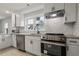 Modern kitchen with white cabinets, granite countertops, stainless steel appliances, and mosaic backsplash at 3006 Dogwood Dr, Hapeville, GA 30354