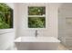 Modern bathroom with soaking tub, sleek fixtures, and scenic outdoor views at 306 Pinecrest Ne Rd, Atlanta, GA 30342