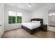 A bedroom with a large window, fan, wood floors, and a bathroom view at 306 Pinecrest Ne Rd, Atlanta, GA 30342