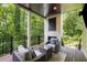 Relaxing covered deck with outdoor seating and a cozy fireplace, surrounded by lush greenery at 306 Pinecrest Ne Rd, Atlanta, GA 30342