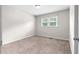 This bedroom features neutral walls, carpet, a window, and a ceiling light at 3990 N Quail Dr, Douglasville, GA 30135
