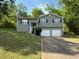 Charming split-level home featuring a two-car garage and neatly maintained front yard with mature trees at 3990 N Quail Dr, Douglasville, GA 30135