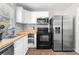 Updated kitchen with stainless steel appliances, white cabinets, and sleek backsplash at 3990 N Quail Dr, Douglasville, GA 30135