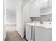 This laundry room features a washer, a dryer, white cabinetry and neutral colored walls at 3990 N Quail Dr, Douglasville, GA 30135
