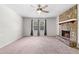 Inviting living room showcasing a stone fireplace, ceiling fan, and two windows for natural light at 3990 N Quail Dr, Douglasville, GA 30135