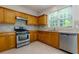 Traditional kitchen with wooden cabinets, stainless steel appliances, and a bright window at 808 Plaintain Dr, Woodstock, GA 30188