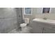 Modern bathroom with new tile flooring and shower with sliding glass door at 2035 Northland Dr, Lawrenceville, GA 30044