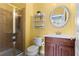 Bright bathroom featuring a glass enclosed shower and a vanity with a round mirror at 2343 Limehurst Ne Dr, Atlanta, GA 30319