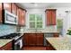Well-lit kitchen featuring granite counters, stainless steel appliances, blue backsplash, and rich brown cabinets at 2343 Limehurst Ne Dr, Atlanta, GA 30319