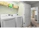 Bright laundry room features modern washer and dryer and overhead shelving at 2343 Limehurst Ne Dr, Atlanta, GA 30319