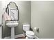 Stylish powder room featuring a pedestal sink, elegant mirror, and modern fixtures at 2343 Limehurst Ne Dr, Atlanta, GA 30319