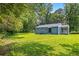The backyard features lush grass, mature trees, and the back of the home with an attached sunroom at 3211 Hollydale Drive Sw, Atlanta, GA 30311