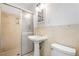 A bathroom features a pedestal sink, sliding glass shower doors, and a toilet at 3211 Hollydale Drive Sw, Atlanta, GA 30311